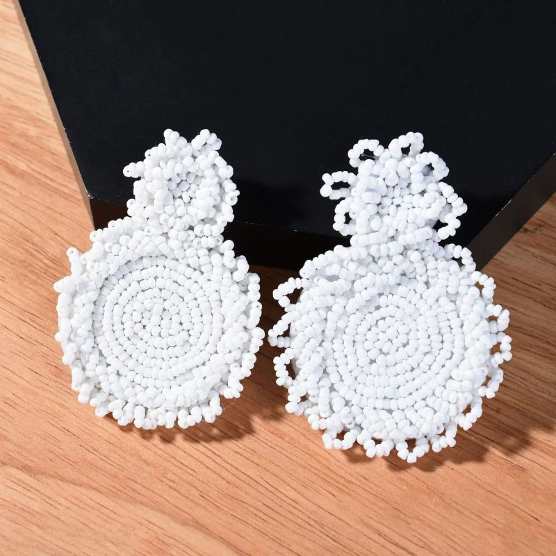 Boucle D'oreille Bohème Chic en Perles blanches, , posées sur un présentoir noir. Image