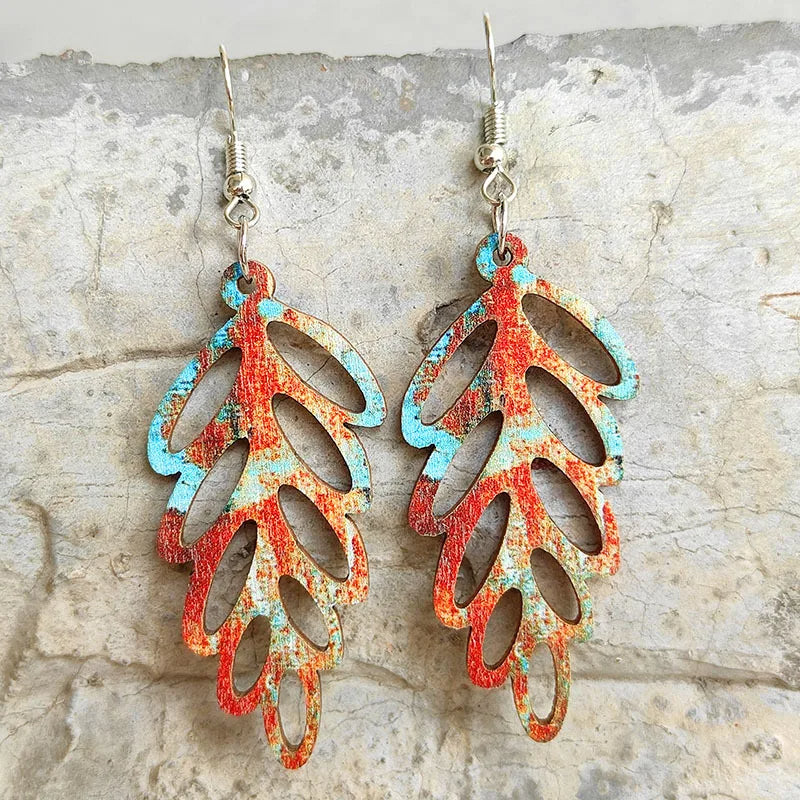 Boucle d'Oreille en Bois Colorée en Forme de Plante accrochée sur un mur