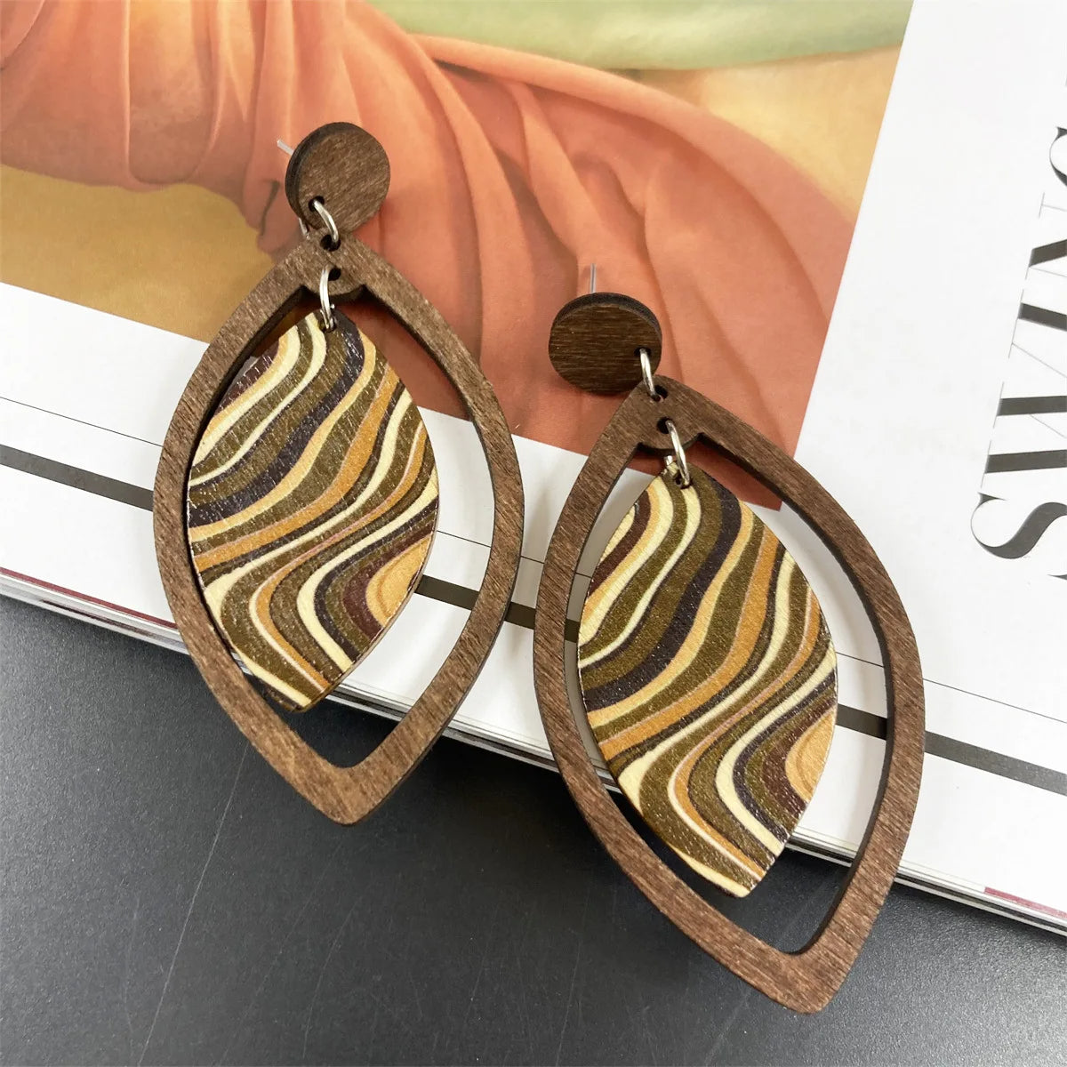 Boucle d'Oreille en Bois Décontractée au Style Bohème posée sur un livre  Image