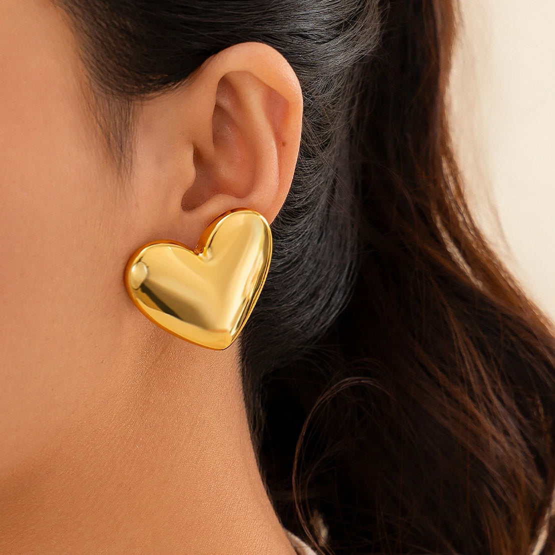 Boucle d'Oreille Coeur Dorée Élégante portée par une femme