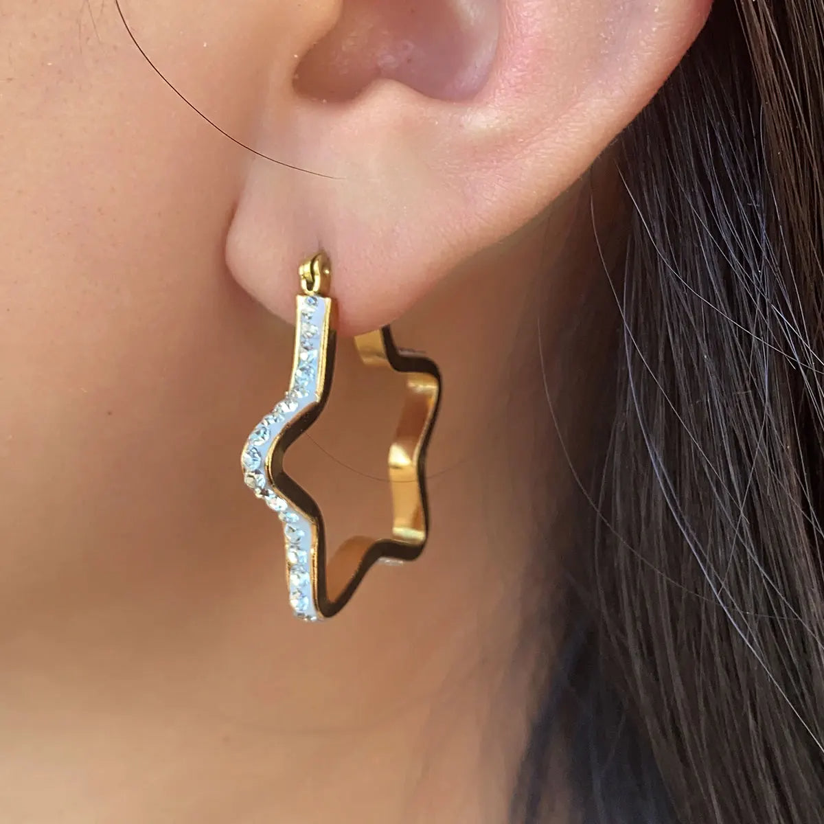 Boucle d'Oreille Etoile Résistante et Durable portée par une femme Image