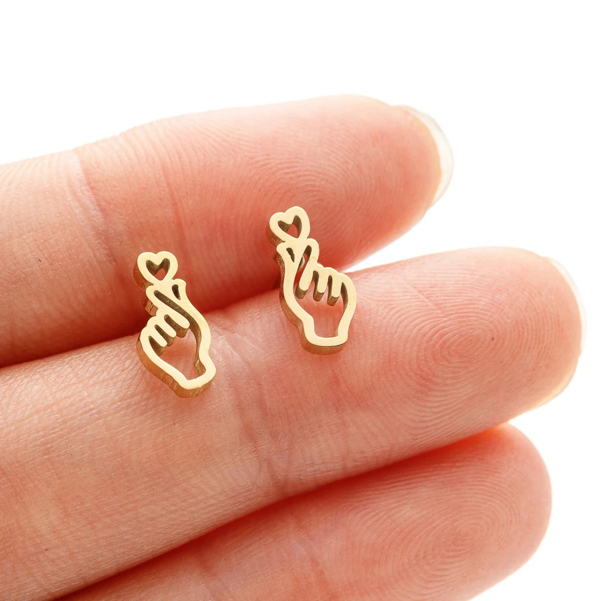 Boucle d'Oreille Femme Puce en Forme de Cœur posé sur une main Image