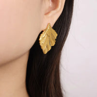 Boucle d'Oreille Feuille Raffinée et Élégante portée par une femme