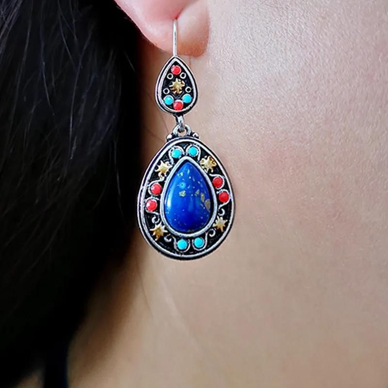 Boucle D'oreille Goutte Ethnique Bleu, porté par une manequin, on ne voit que le lobe et son cou.