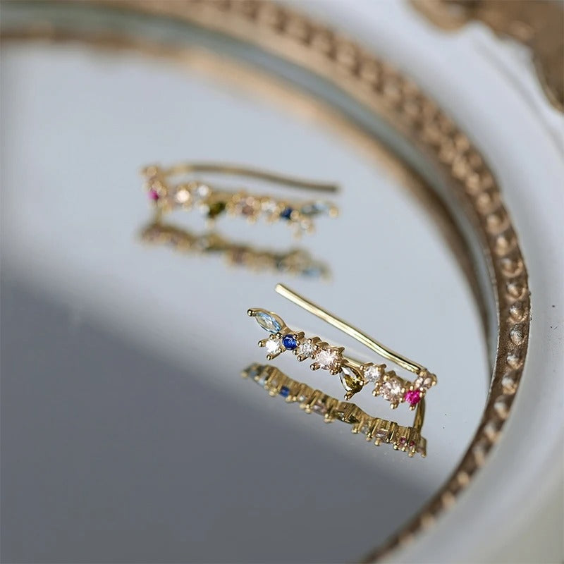 Boucle d'Oreille Grimpante doré sur un miroir Image