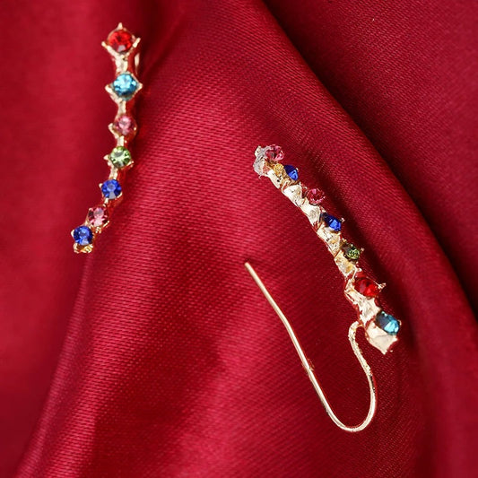 Boucle d'Oreille Grimpante à strass sur un tissu rouge 