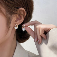 Boucle d'Oreille Luxe Femme en Forme de Goutte d'Eau porté par une femme