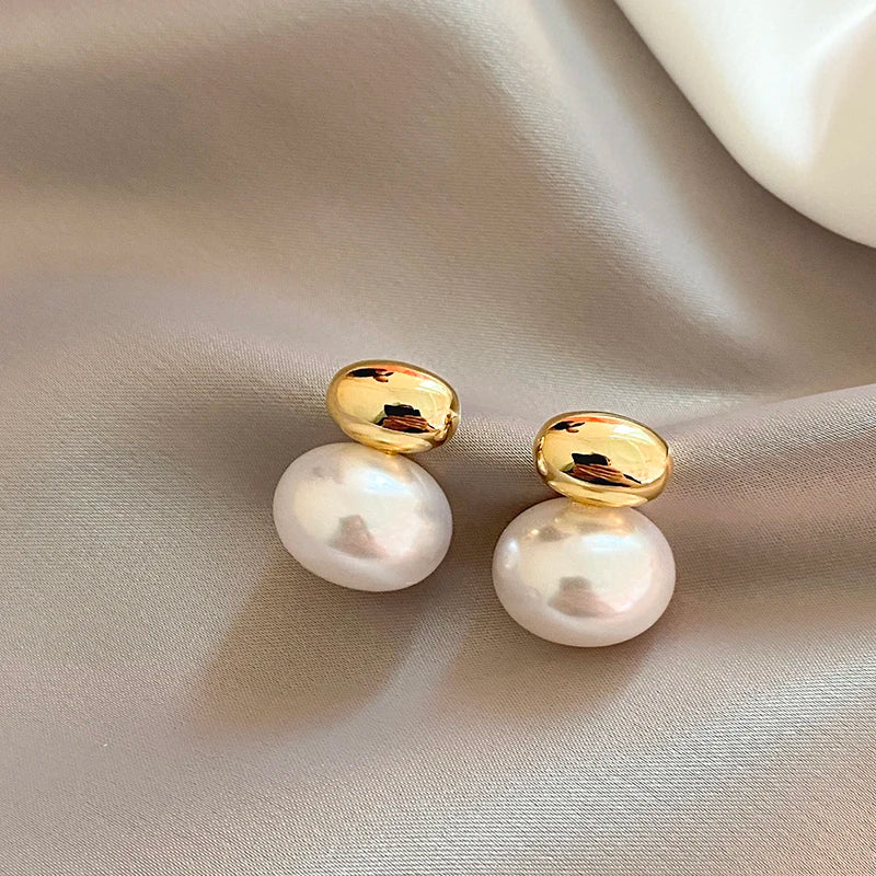 Boucle D'oreille Perle Blanche Élégante et Raffinée posée sur un tissu Image
