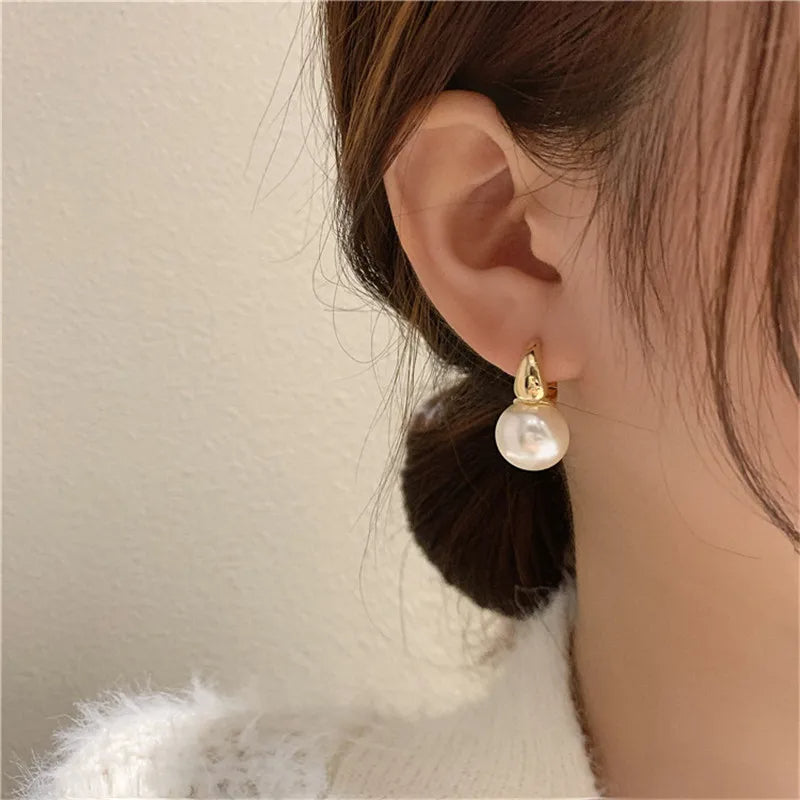 Boucle D'oreille Perle Blanche Légère et Confortable portée par une femme Image