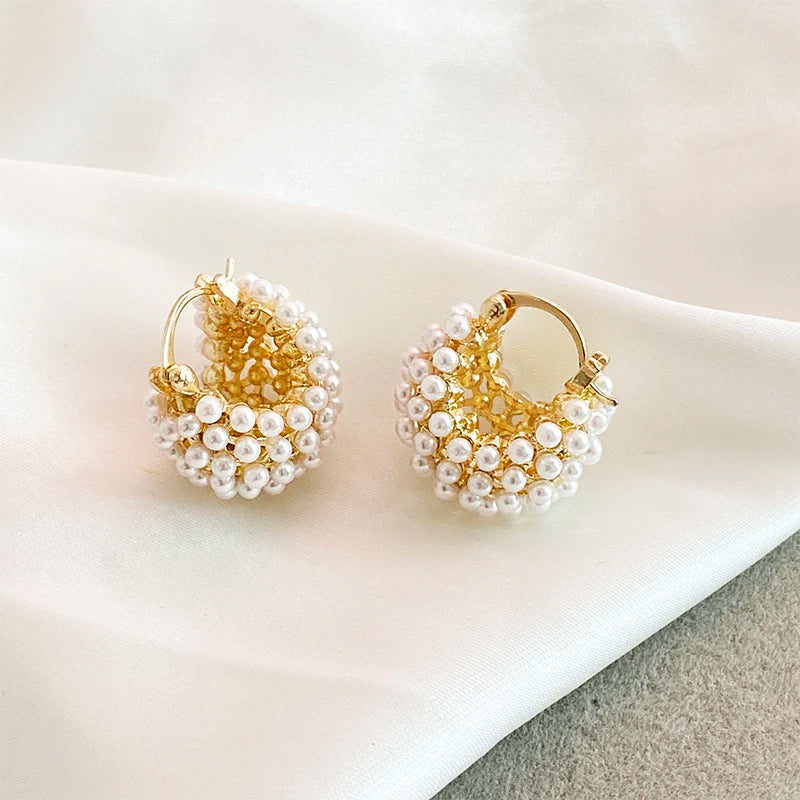 Boucle d'Oreille Perle Chic et Brillante posée sur un tissu Image