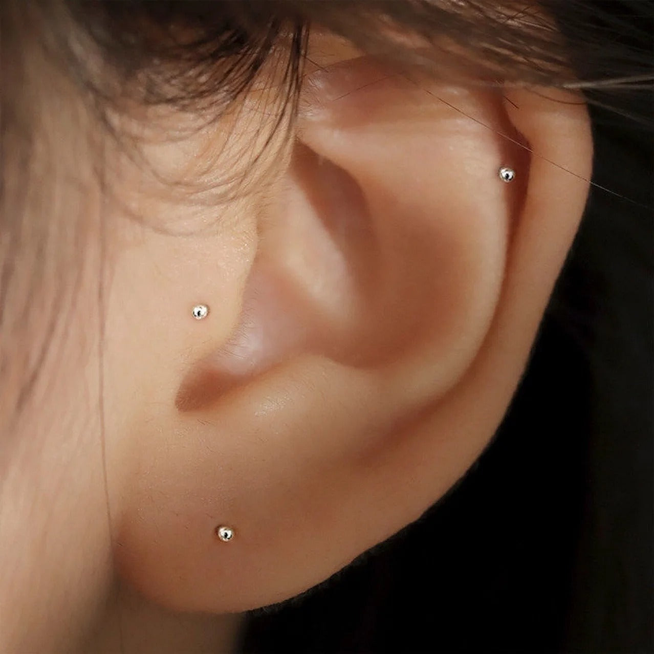 Boucle d'Oreille Puce Petites Boules portées sur une oreille de femme Image