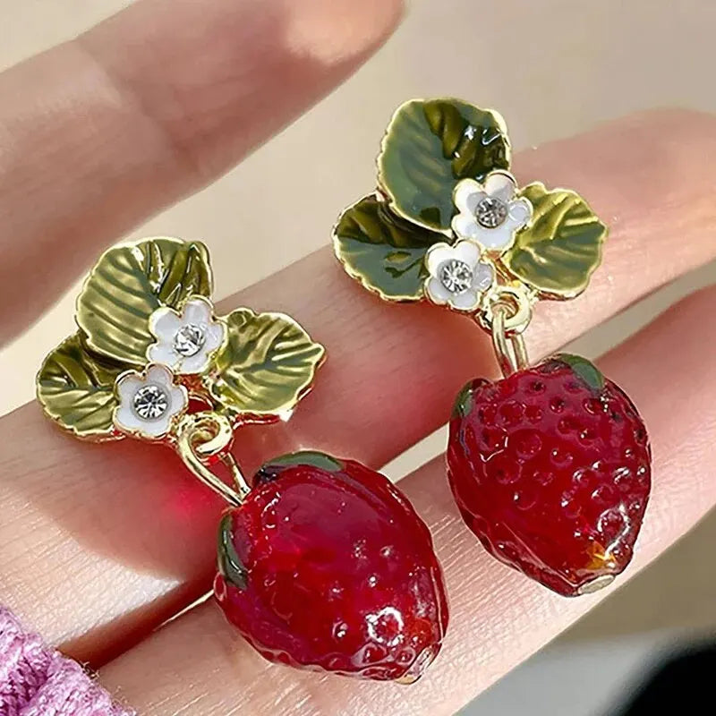 Boucle d'Oreille Rouge Sophistiquée en Forme de Fraise tenue dans une main Image