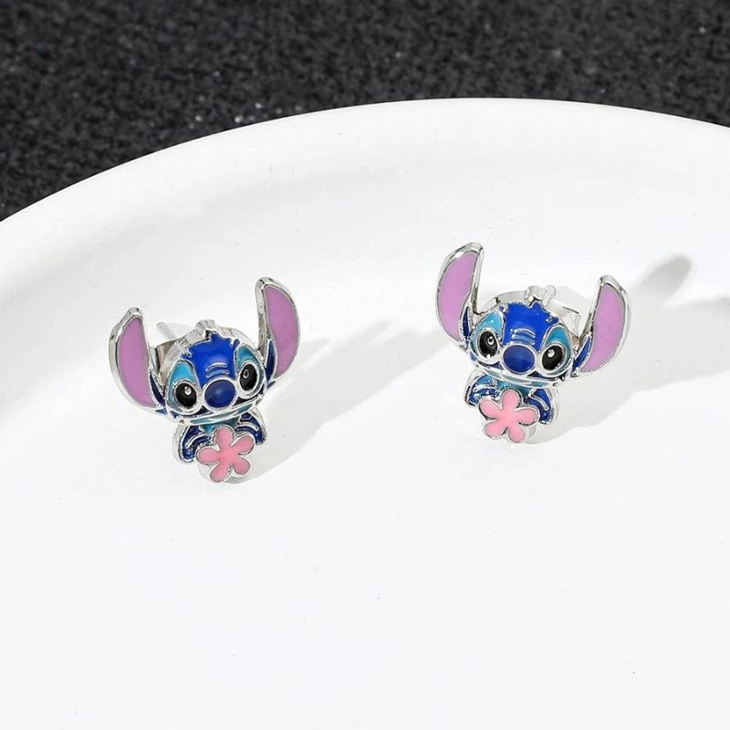 Boucle D'oreille Stitch Fleur Rose, les deux boucles sont posées sur une genre d'assiette blanche.