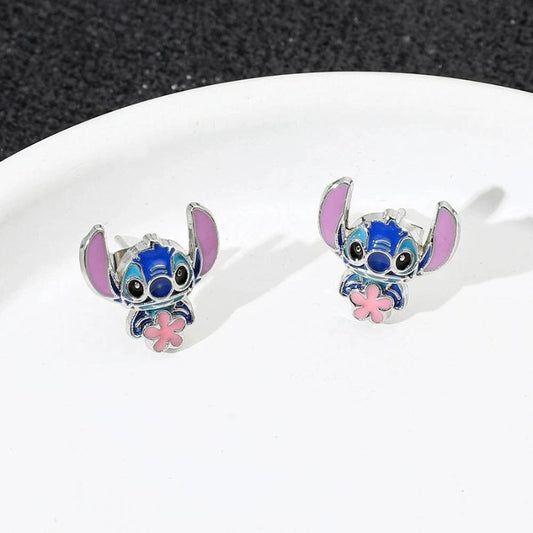 Boucle D'oreille Stitch Fleur Rose, les deux boucles sont posées sur une genre d'assiette blanche.