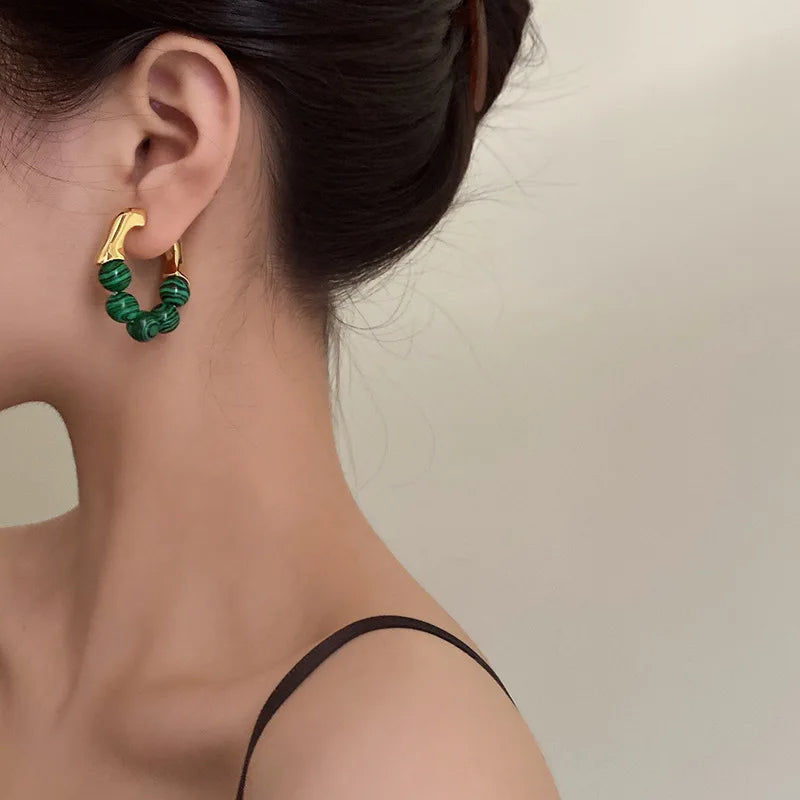 Boucle d'Oreille Verte Résistante et Durable portée par une femme