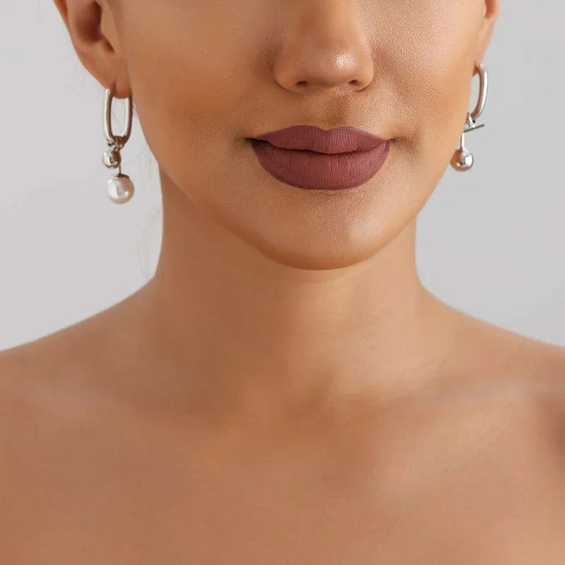 Boucles D'oreilles Asymétriques Perles Pendantes portées par une femme on voit le bas de son visage et le haute de ses épaules.
