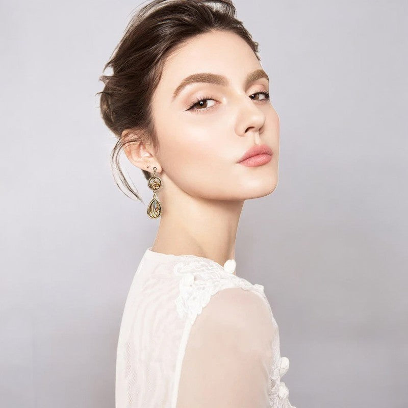 Boucles D'oreilles Clips Pendantes portée par une femme qui pose de trois quart Image