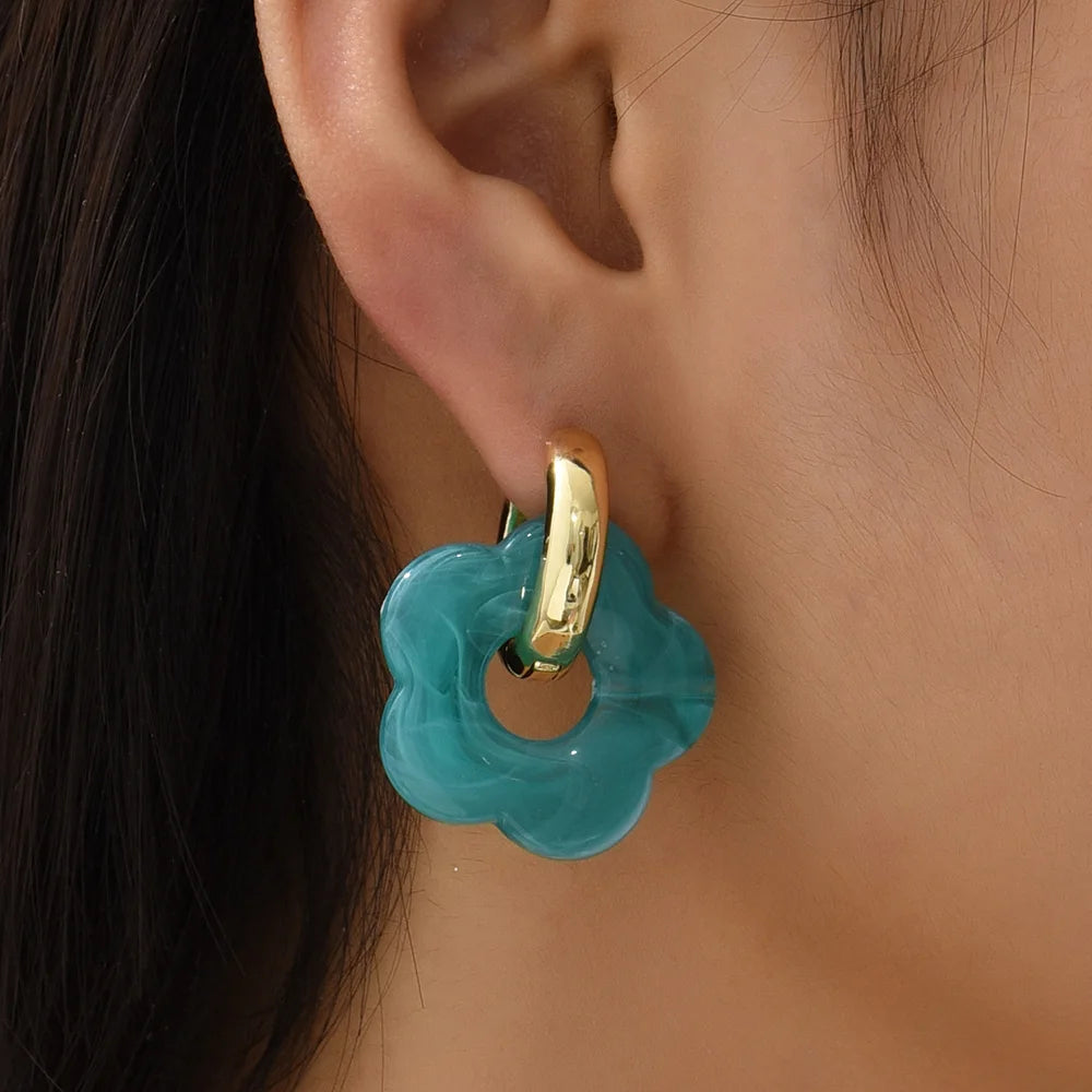 Boucles D'oreilles Pendantes Originales Fleur Colorée Amovible bleue, portée par une femme de profil.