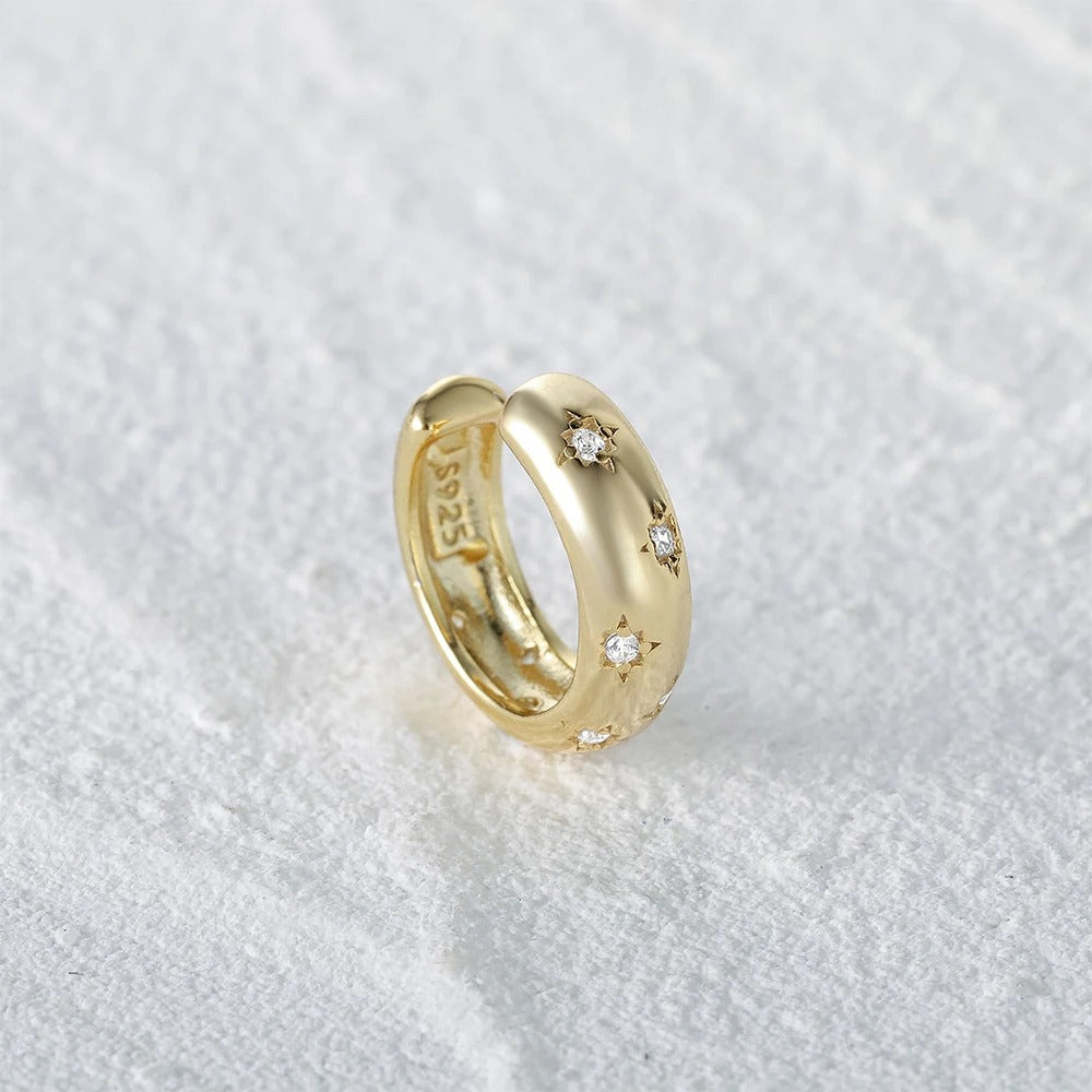 Ear Cuff Femme Doré avec Zircon Microincrusté posé sur un linge blanc, avec le tempon "S925" visibleà l'intérieur.