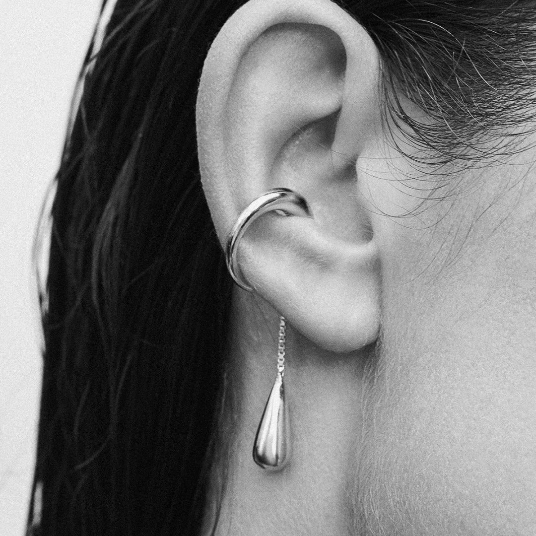 Ear Cuff Pendante Style Larme, porté par une femme. La photo est en noire et blanc.