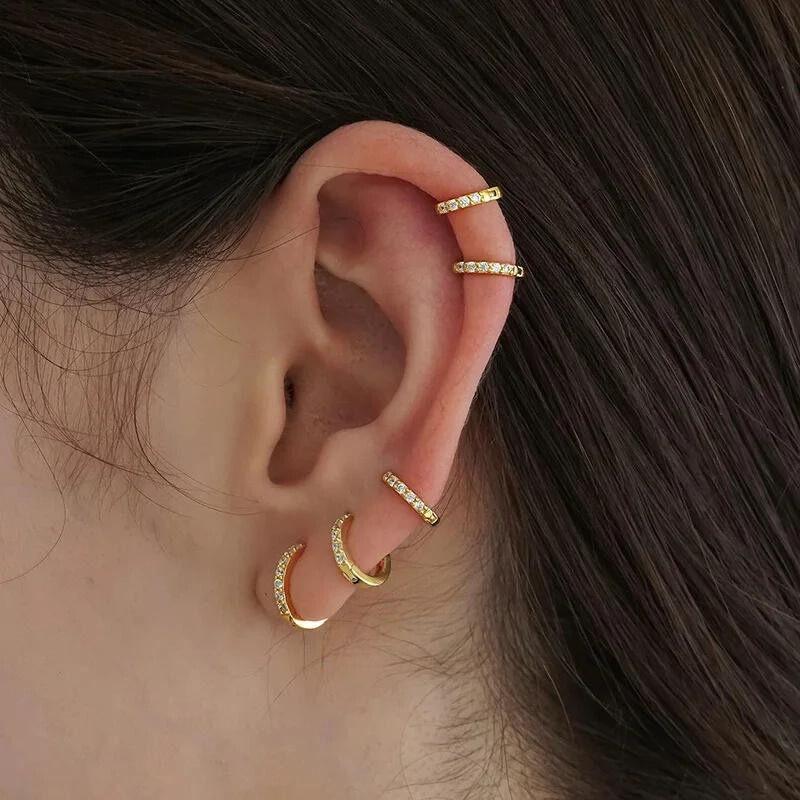 Lot 7 Paires Boucle D'Oreille Acier Inoxydable. Jeune femme de profil portant 5 anneaux sur son oreille. Image