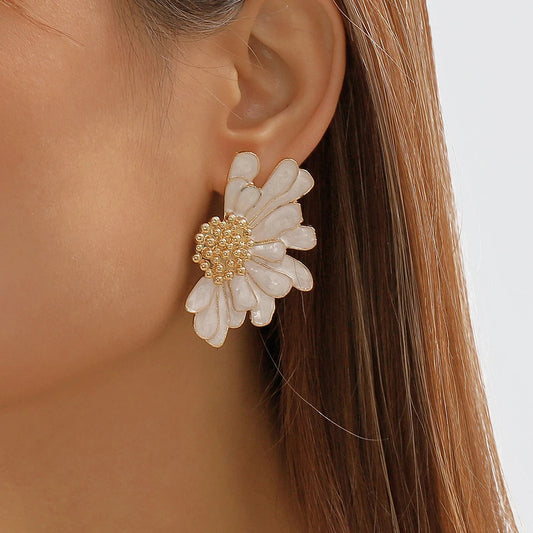 Boucle D'oreille Fantaisie Fleur Asymétrique blanche et dorée portée par une mannequin de profil.